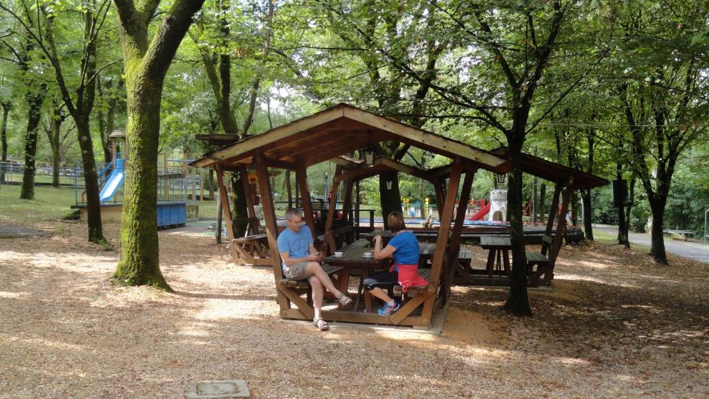 a group of people sitting in a gazebo in a park at Camping al Lago in Tarzo