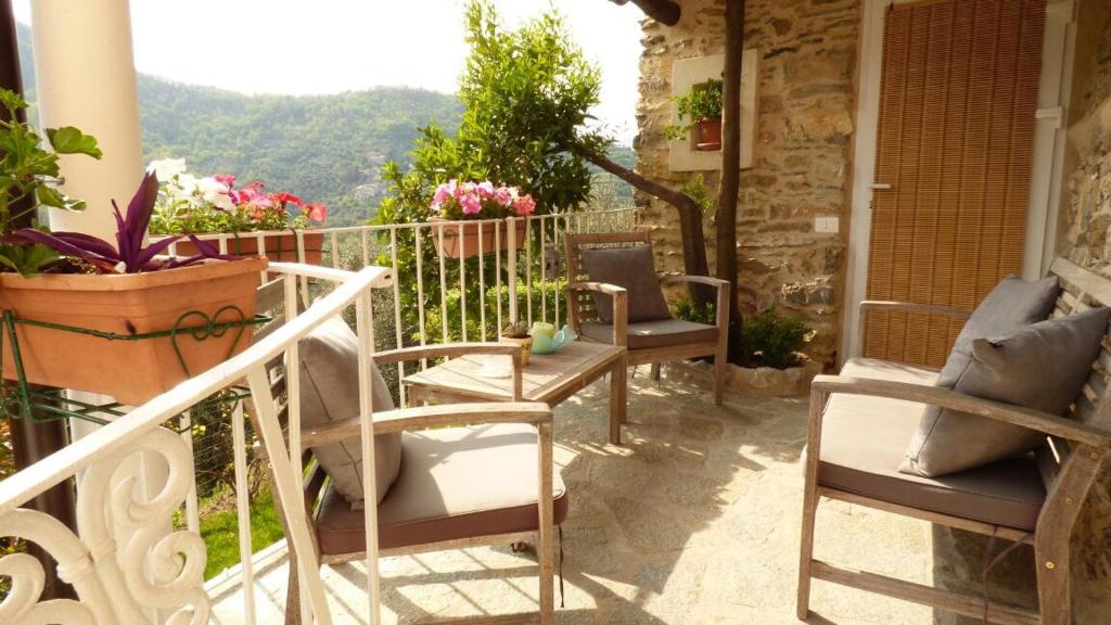 eine Veranda mit Stühlen und Bergblick in der Unterkunft Casa Vacanze Sole in Borghetto dʼArroscia