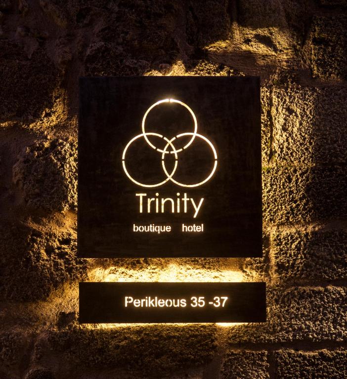 a sign that reads trinity bathroom hotel on a brick wall at Trinity Boutique Hotel in Rhodes Town