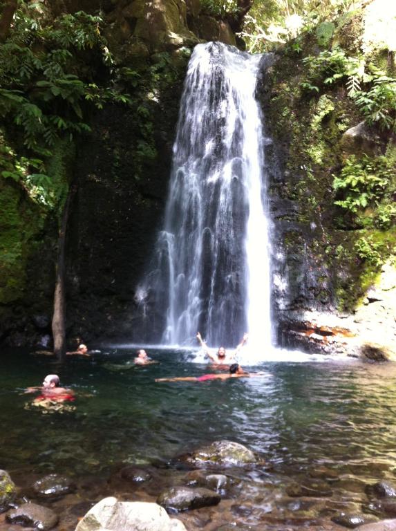 a group of people swimming in a waterfall at Casa Auri in Faial da Terra