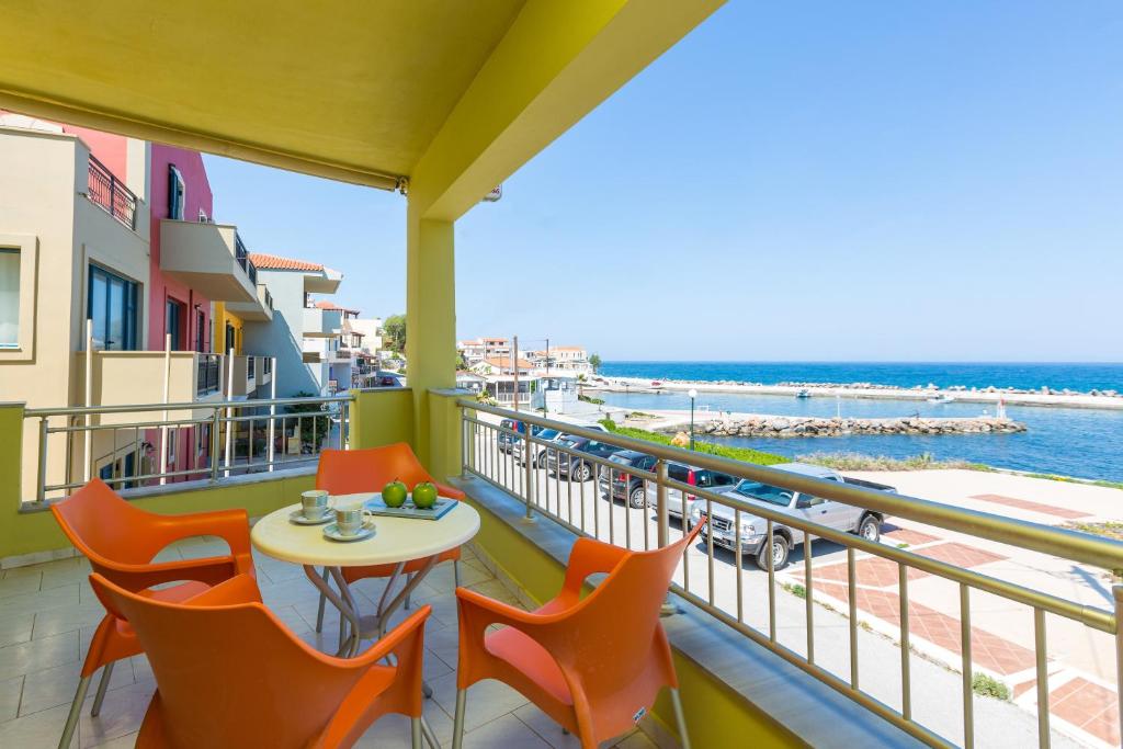 a balcony with chairs and a table and a view of the beach at Glaros in Panormos Rethymno