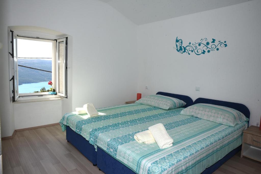 a bedroom with a large bed with a window at Apartment Marija in Vrana