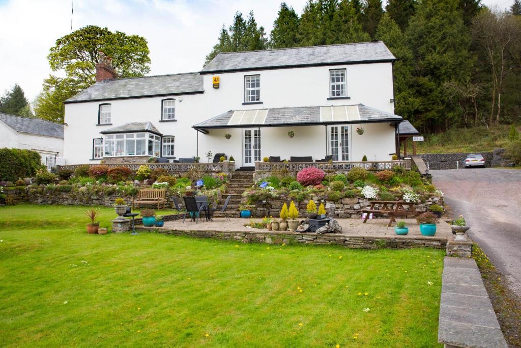 uma casa branca com um jardim em frente em Llwyn Onn Guest House em Merthyr Tydfil