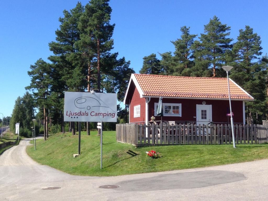 una señal frente a una pequeña casa roja en Ljusdals Camping en Ljusdal