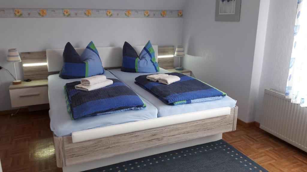 a bedroom with two beds with blue pillows at Ferienwohnungen Steeg in Braunlage