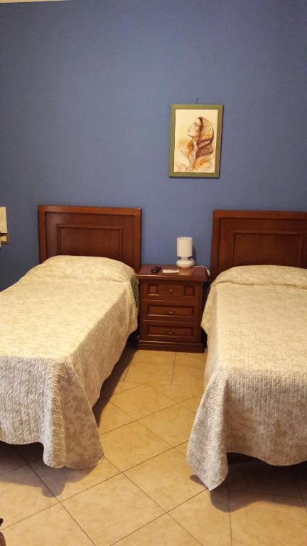 1 dormitorio con 2 camas y una foto en la pared en La Villa Del Patrizio, en Ostia Antica