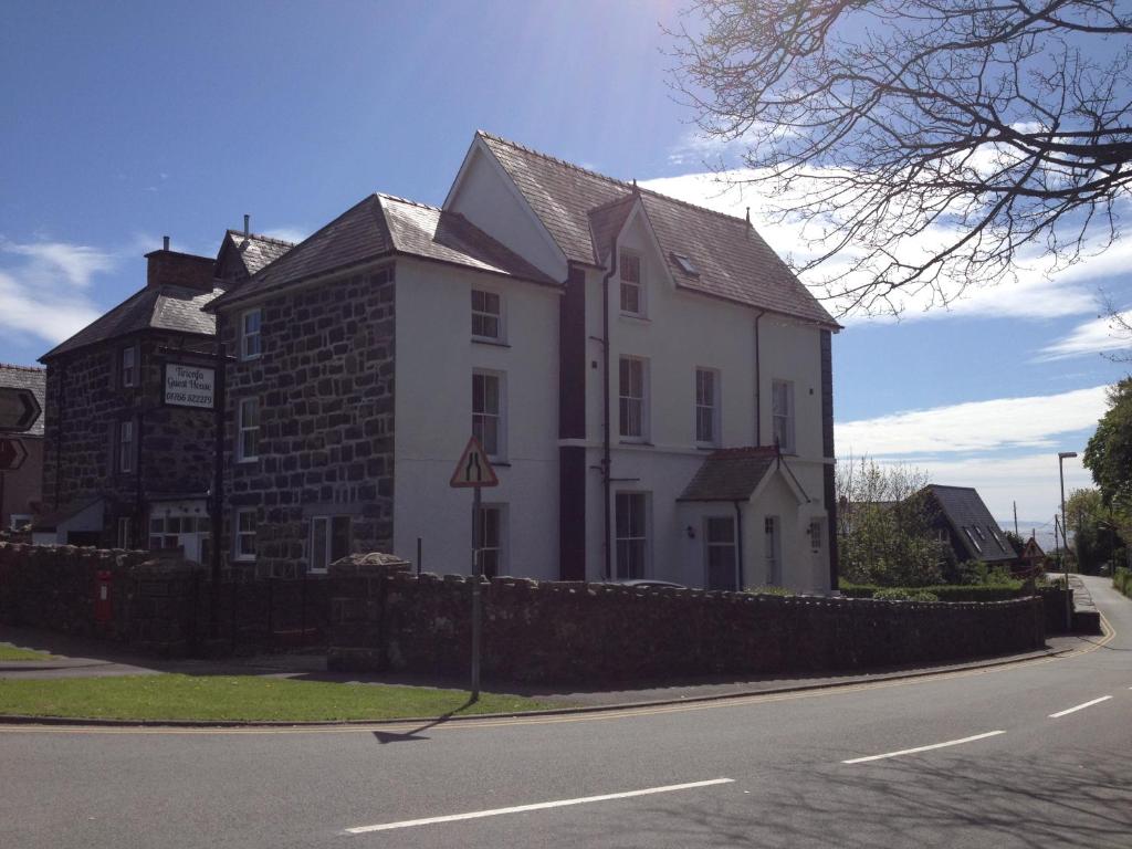 a large white building on the side of a street at Tirionfa Guest House in Criccieth