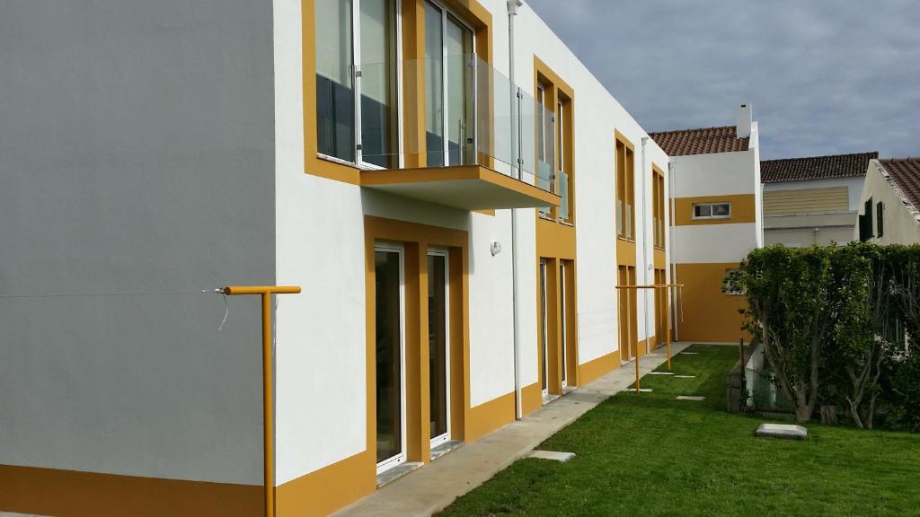 a building with a balcony on the side of it at São Pedro Apartamentos in Horta