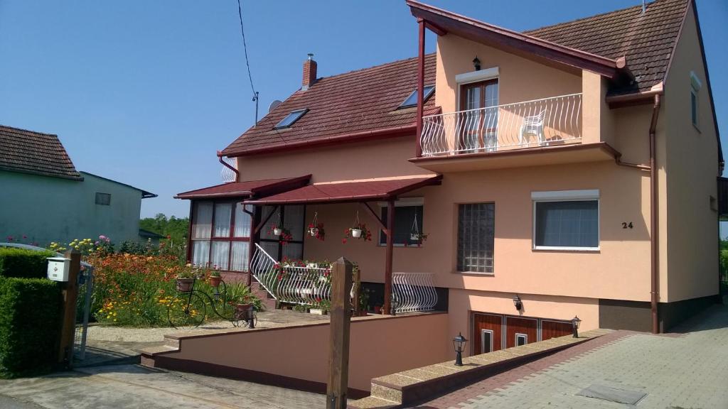 a house with a balcony and a dog on the balcony at Dávid Apartmanház in Zalakaros