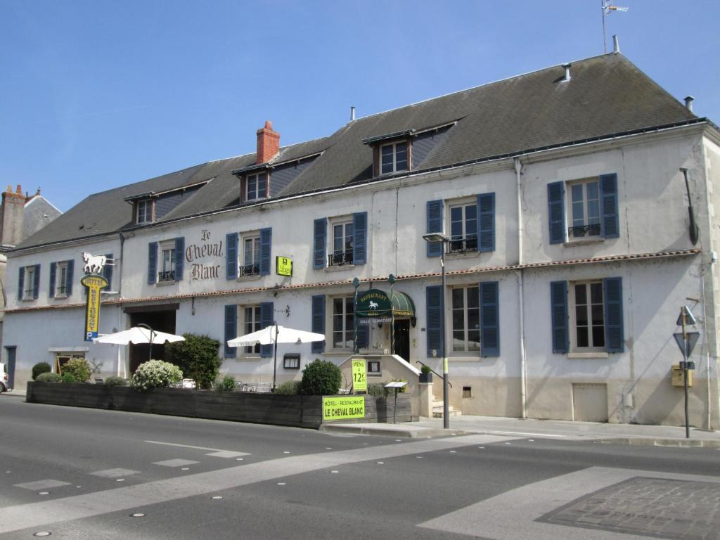 een wit gebouw op de hoek van een straat bij Logis Hostellerie Du Cheval Blanc in Sainte-Maure-de-Touraine