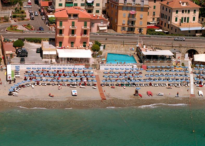 una playa con un montón de gente sentada en la playa en Hotel Bianca Maria, en Varazze