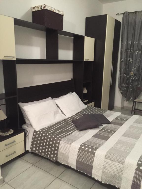 a bedroom with a bed with a black and white comforter at Casa Olbia in Olbia