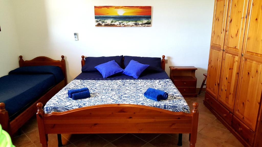 Un dormitorio con una cama con almohadas azules. en Su Sattisceddu, en Uras