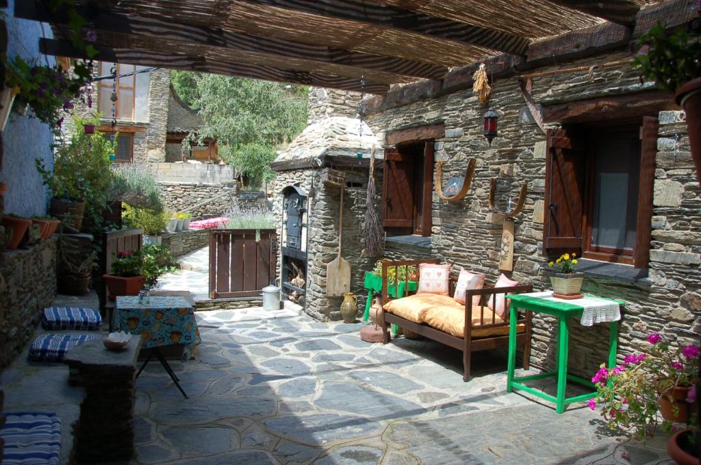 een patio met een bank en een stenen gebouw bij La Coberta-Lo Paller del Coc in Rialp