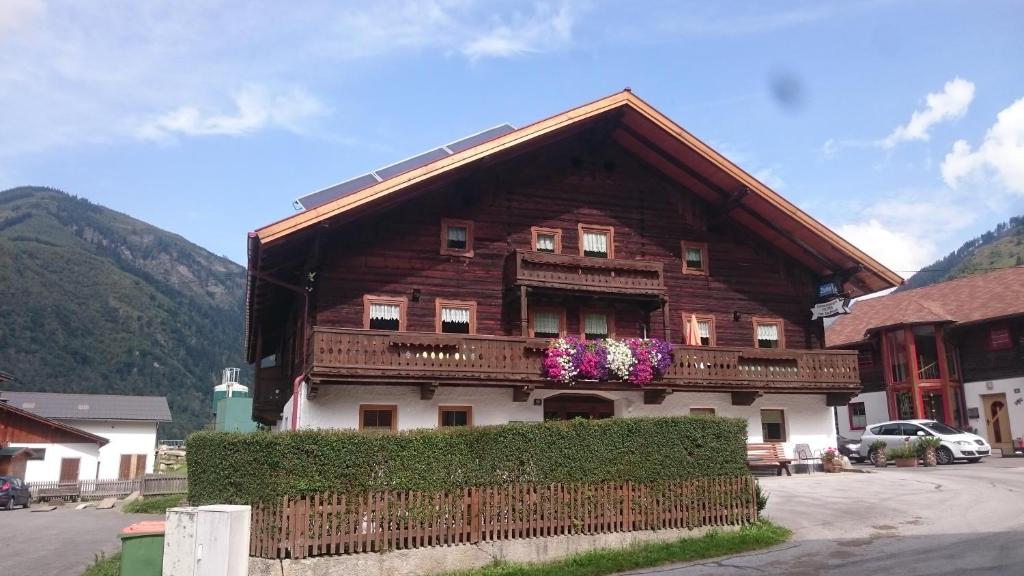 a wooden house with flowers in front of it at Palfner in Rauris