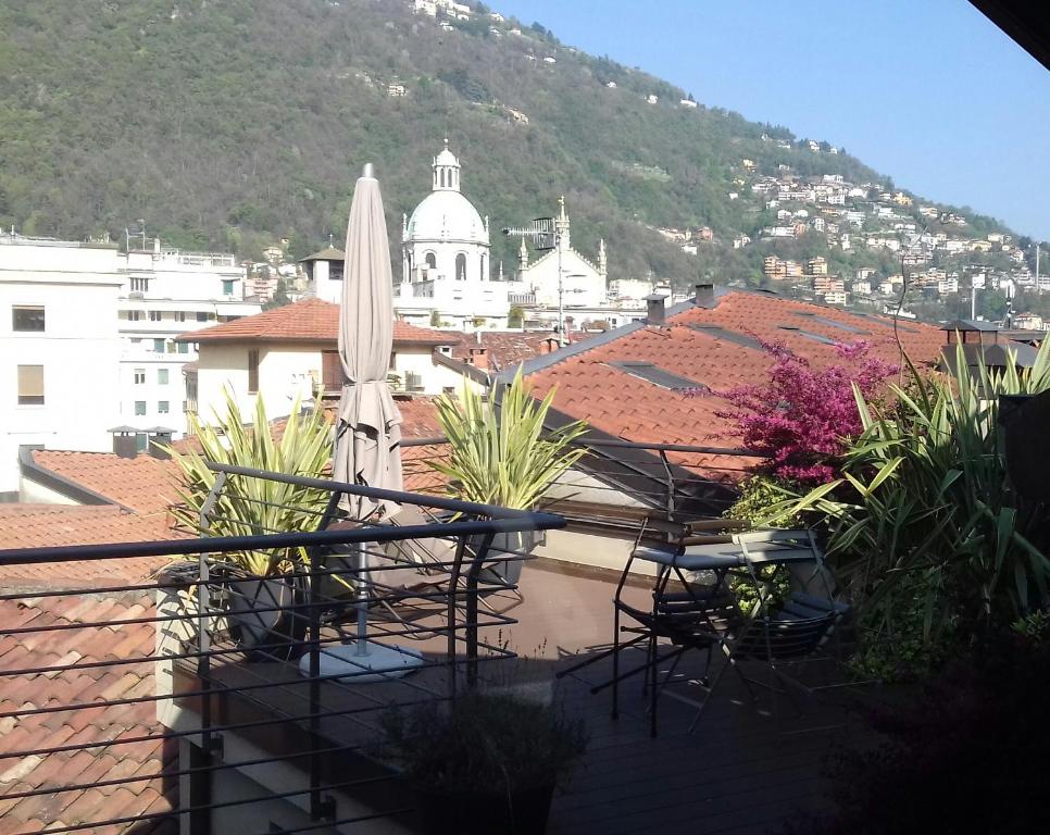 balcone con sedie e ombrellone sul tetto di Como Via Carcano 13 a Como