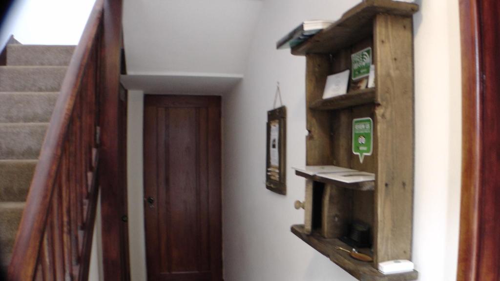 a hallway with stairs and a wooden cabinet and a door at Bay Lodge in Birchington