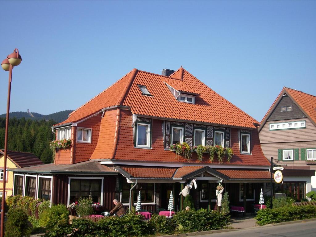 Hotel Brockenstübchen في شيارك: منزل كبير بسقف برتقالي على شارع