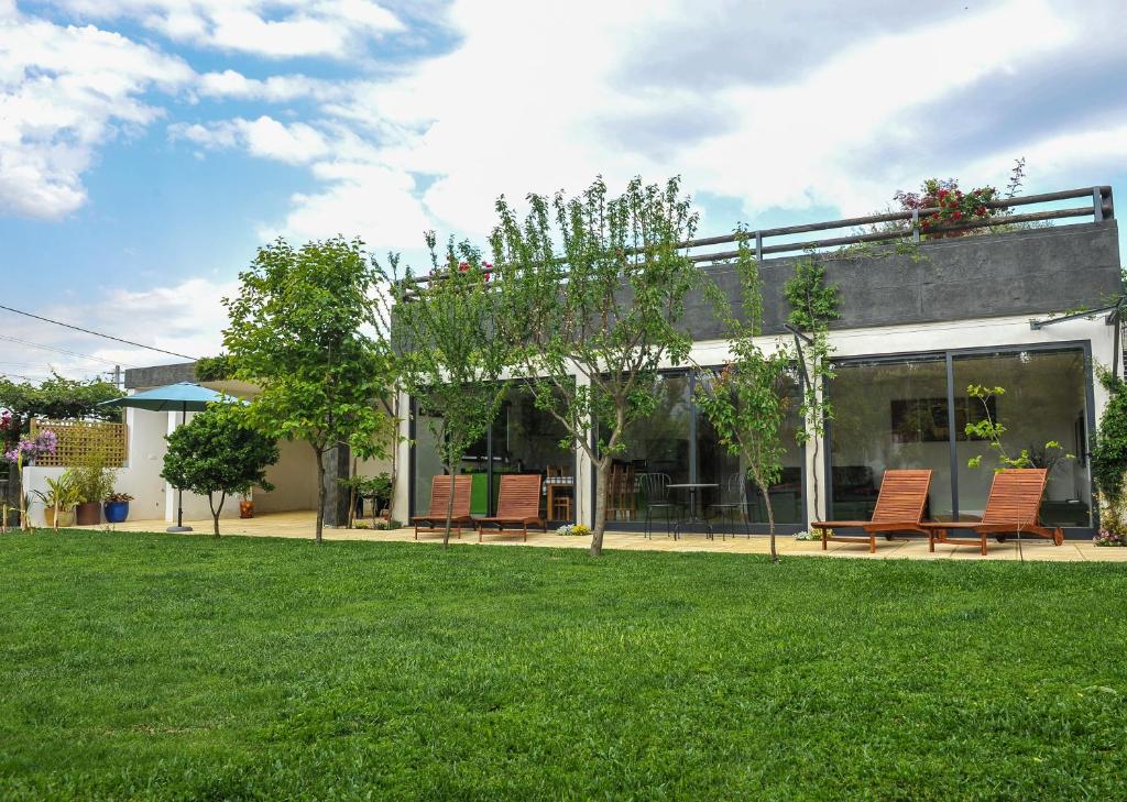 a house with chairs and a lawn in front of it at Casa da Tapada - Grupo Casas Vale do Lima in Ponte de Lima