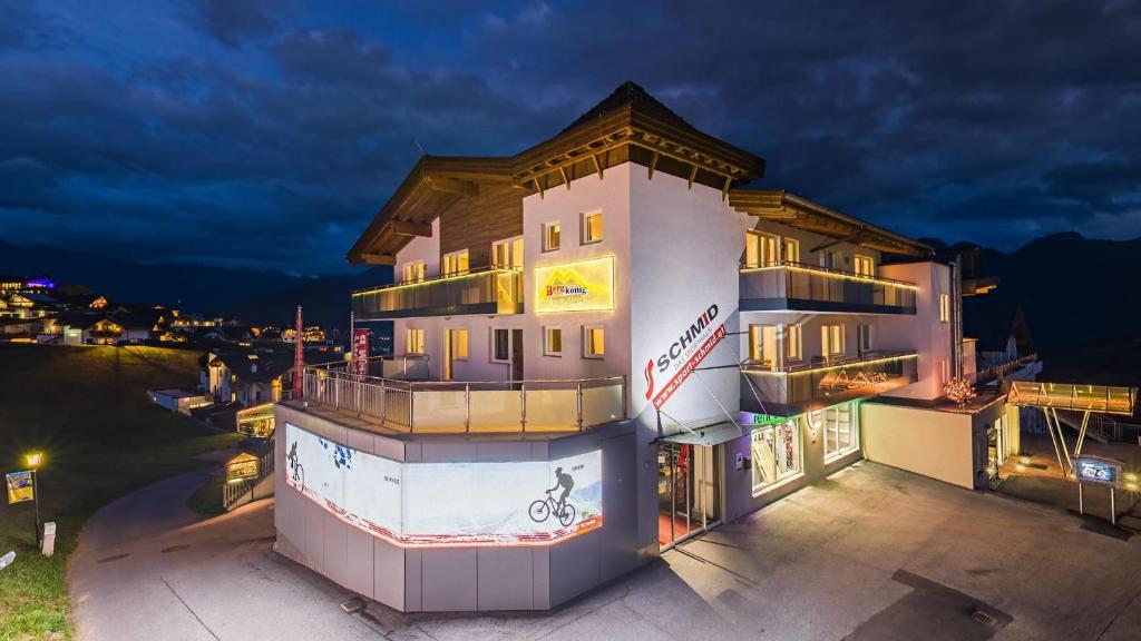 a building with a sign on the side of it at Apart-Hotel Bergkönig in Fiss