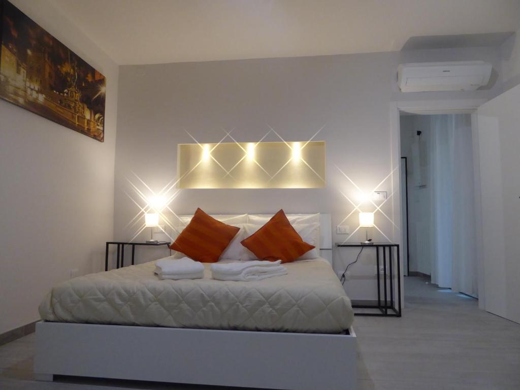 ボローニャにあるMascarella House Bologna - self check-inのベッドルーム1室(壁に照明付きのベッド1台付)