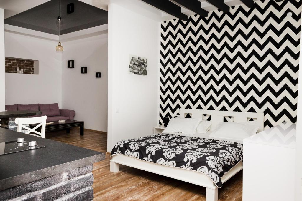 1 dormitorio con una pared a cuadros en blanco y negro en Apartments Zefir on Vynnychenka, en Leópolis