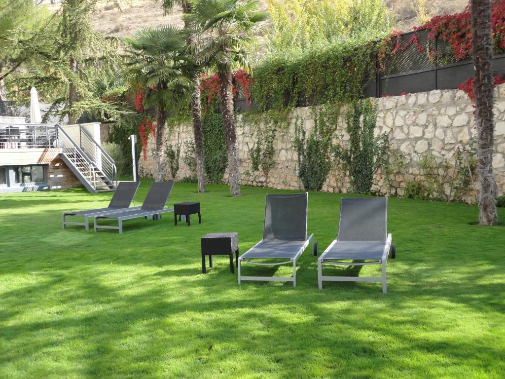 three chairs sitting on the grass in a yard at Hotel Spa Niwa in Brihuega