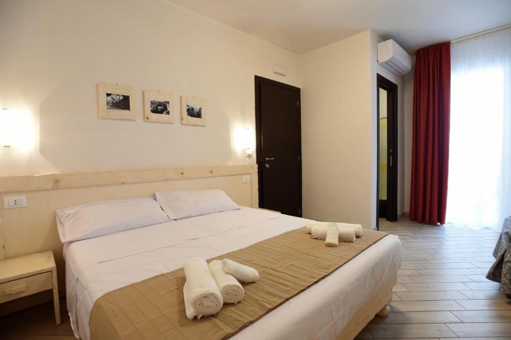 1 dormitorio con 1 cama con toallas en Camere Le Vie di Omero en Torre dell'Orso