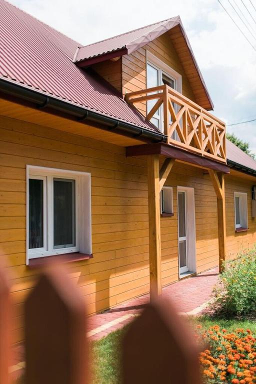 a house with a wooden deck on the side of it at Zamsówka in Guciów