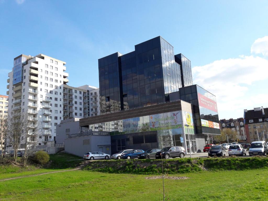 duży budynek z samochodami zaparkowanymi na parkingu w obiekcie Apartament ORANGE Warmia Towers w Olsztynie