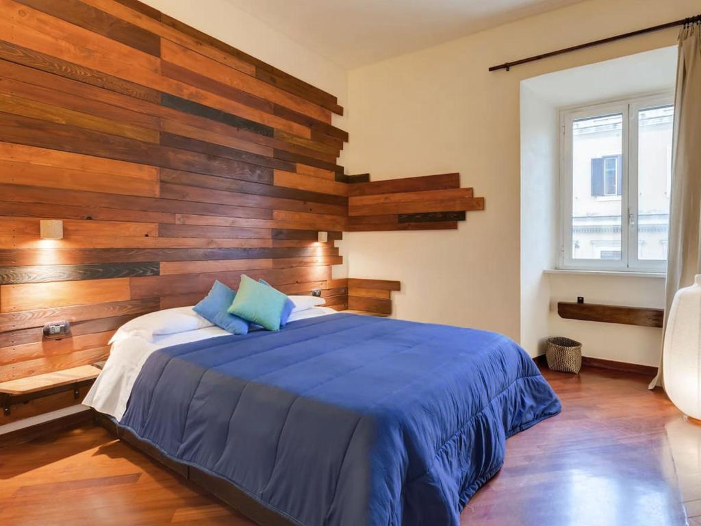 a bedroom with a blue bed with wooden walls at Folia Domus - Vatican City in Rome