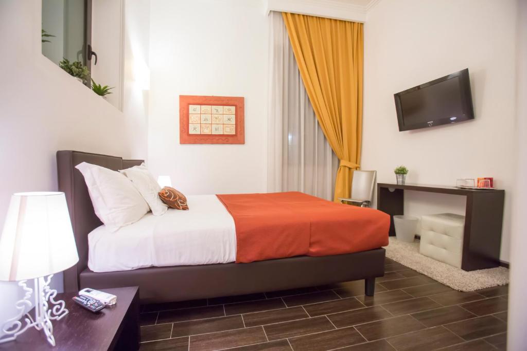 ローマにあるBbqueenのベッドとテレビが備わるホテルルームです。