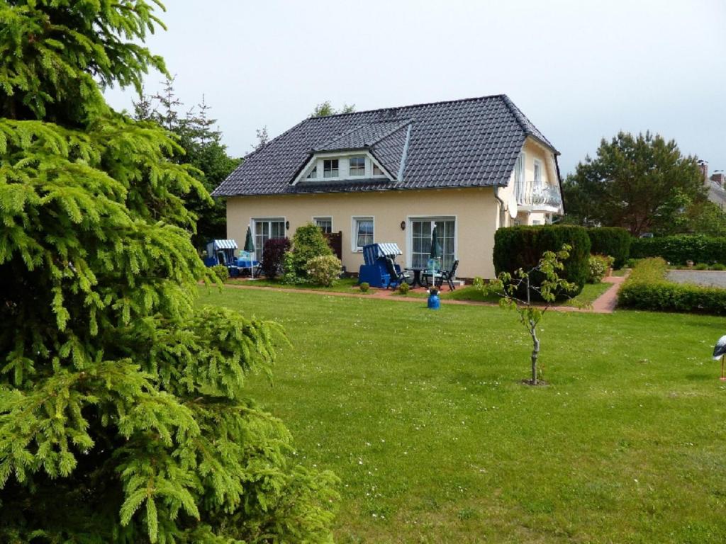 a house with a yard with a green lawn at Gaestehaus Heuer in Baabe