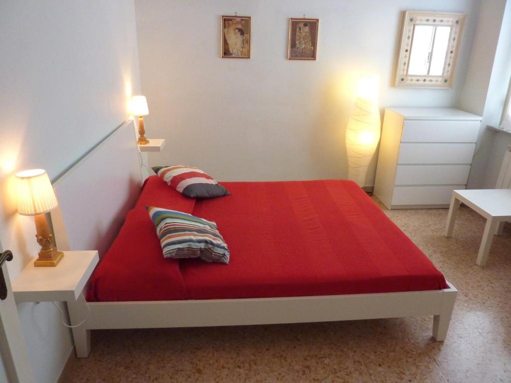 ローマにあるTommy Guest House Romaのベッドルーム1室(赤いベッド1台、ランプ2つ付)