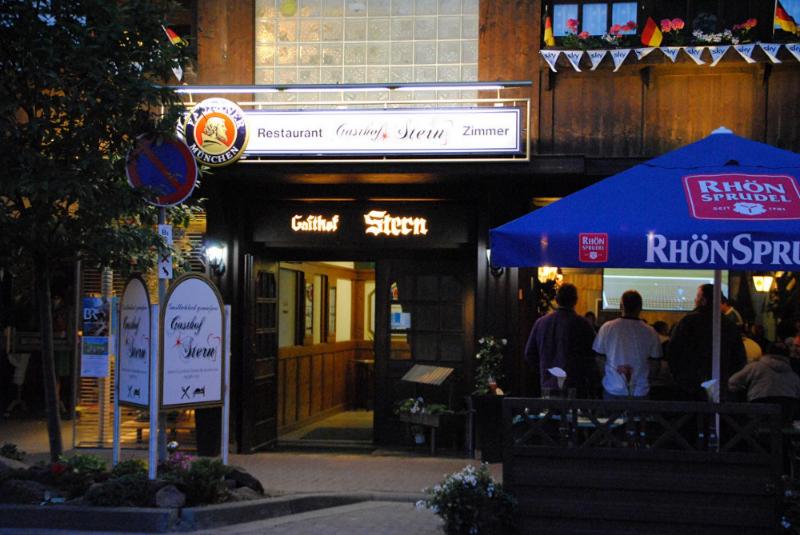 eine Gruppe von Menschen, die nachts vor einem Restaurant stehen in der Unterkunft Gasthof Stern in Burgsinn