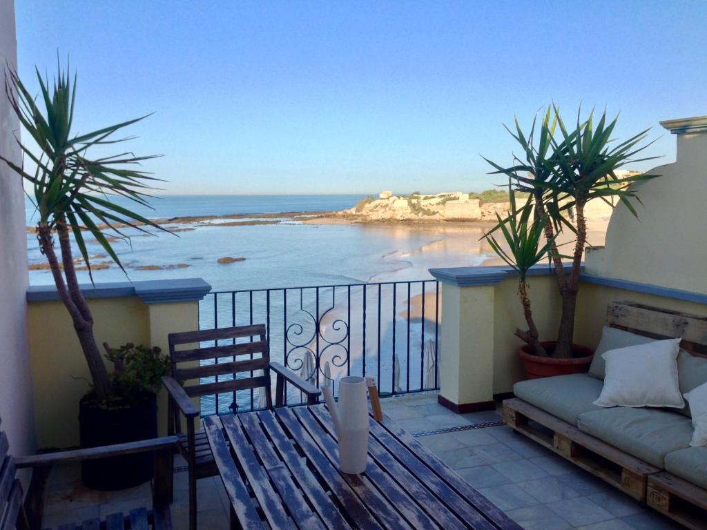 einen Balkon mit einem Sofa und Strandblick in der Unterkunft Ático Playa Muralla in El Puerto de Santa María