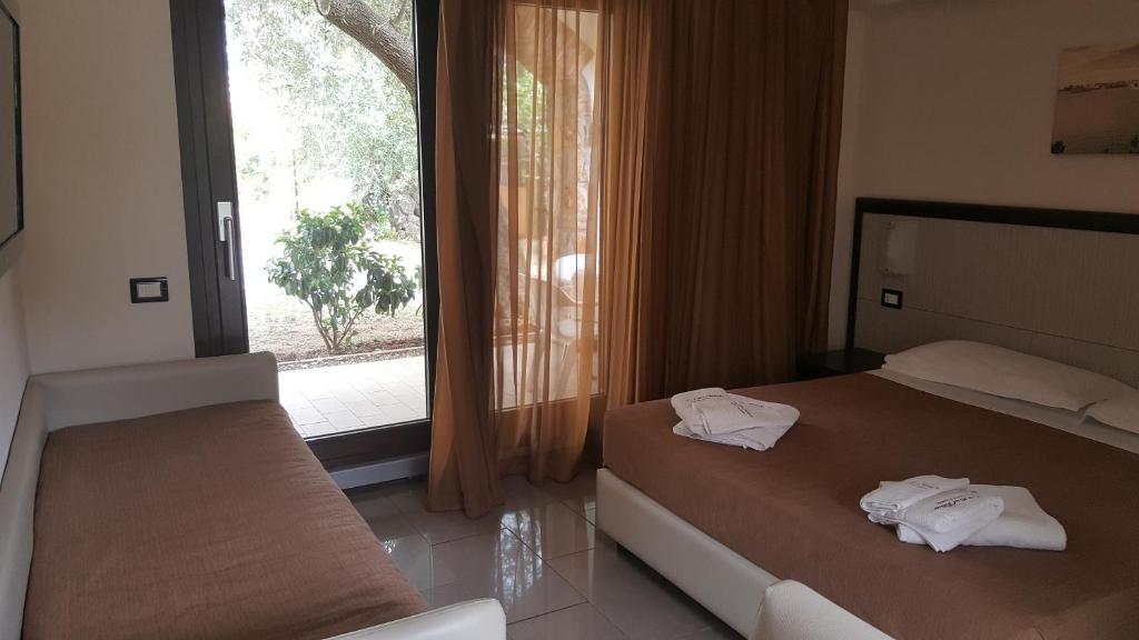 a hotel room with two beds and a window at Park Hotel Cilento in Marina di Camerota