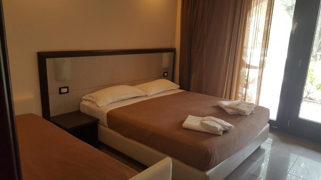 a bedroom with a bed with two towels on it at Park Hotel Cilento in Marina di Camerota