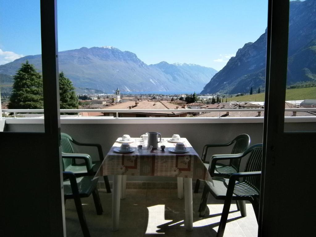 un tavolo su un balcone con vista sulle montagne di Residence Cascata Varone a Riva del Garda