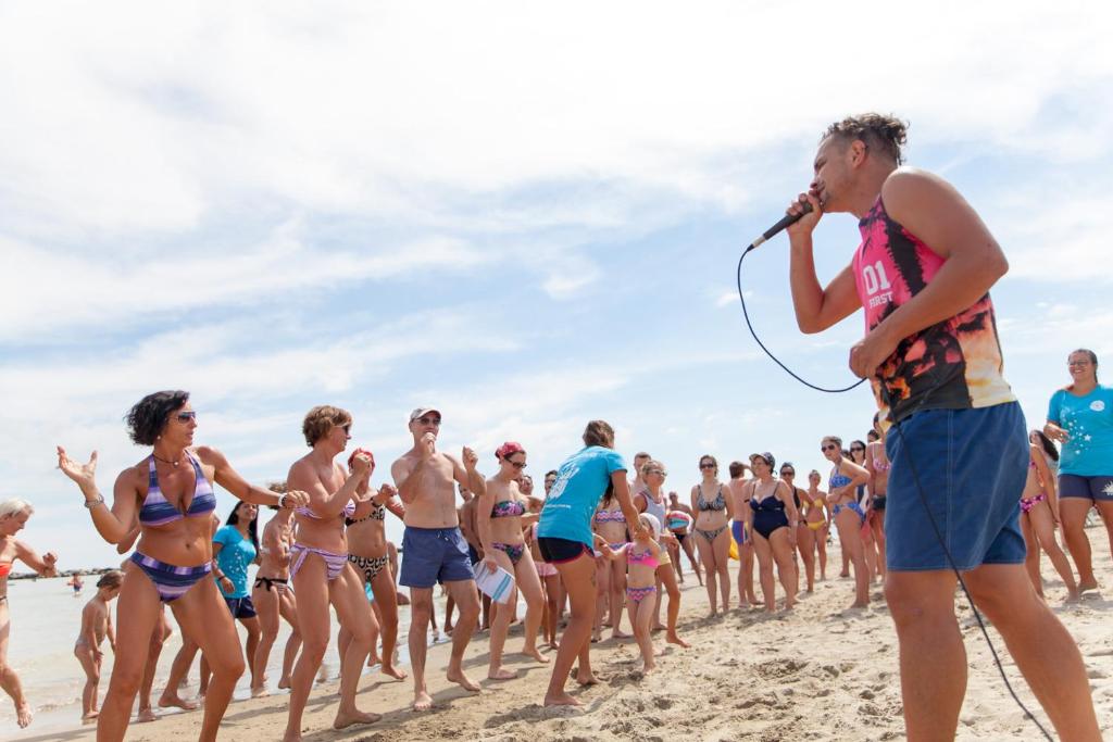 un grupo de personas en traje de baño en la playa en Hotel Villa Boschetti, en San Mauro a Mare