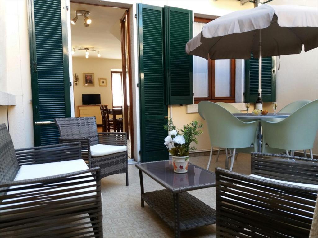 patio con sedie, tavoli e ombrellone di Matteotti House a Bardolino