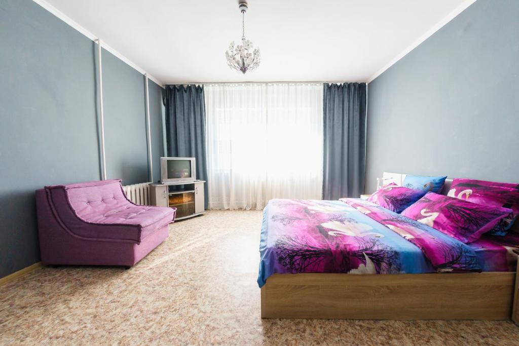 オレンブルクにあるApartment Purple on Tereshkovoy 10/2のベッドルーム1室(ベッド1台、椅子付)