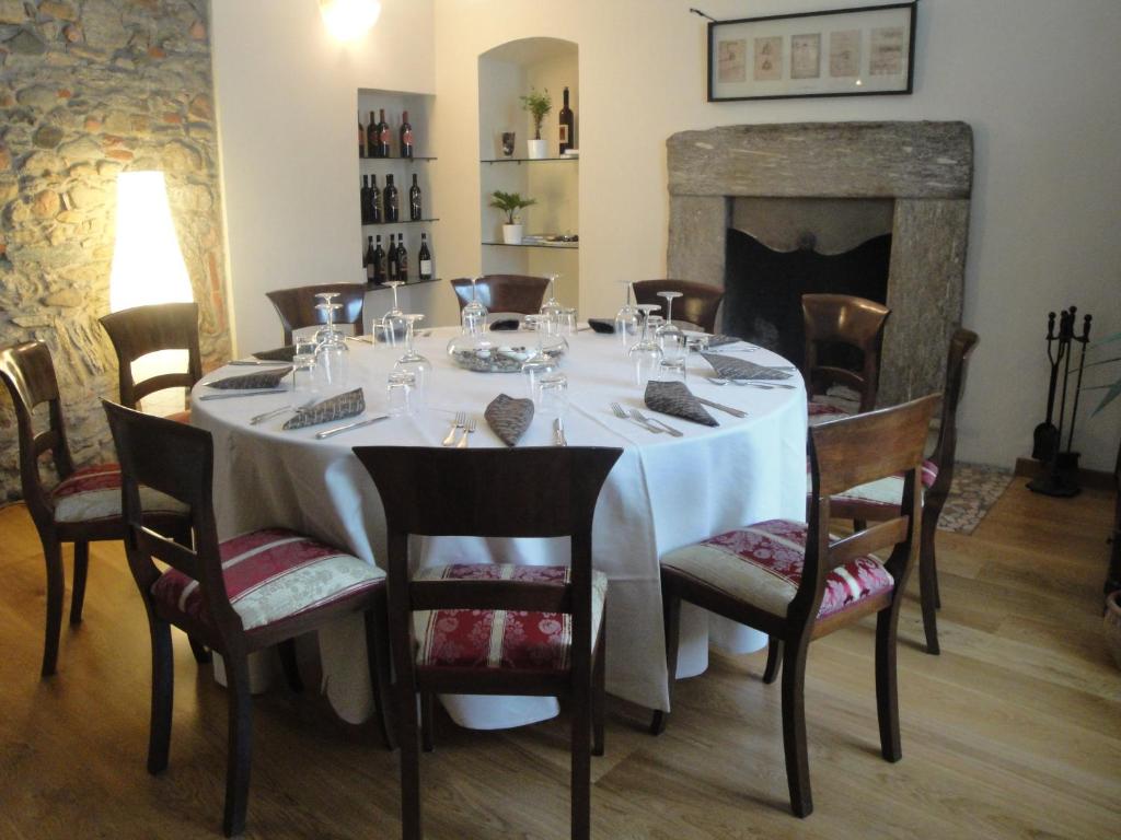 una sala da pranzo con tavolo e camino di Locanda del Brinsc a Brinzio