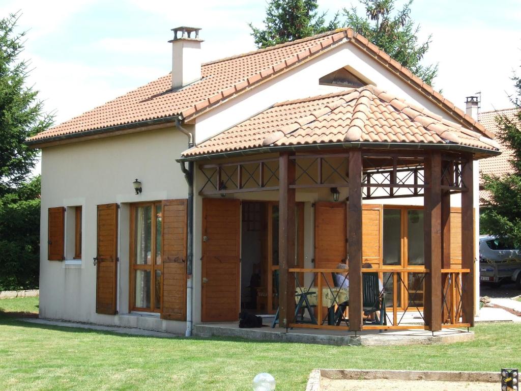 una pequeña casa con un porche envolvente en Lac de Naussac, en Langogne