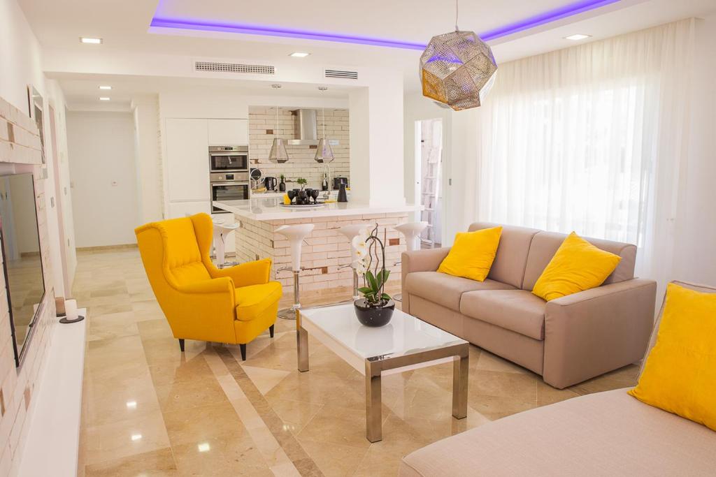 ベナルマデナにあるLuxury 100 sq.m. sea view apartmentのリビングルーム(ソファ、黄色の椅子付)