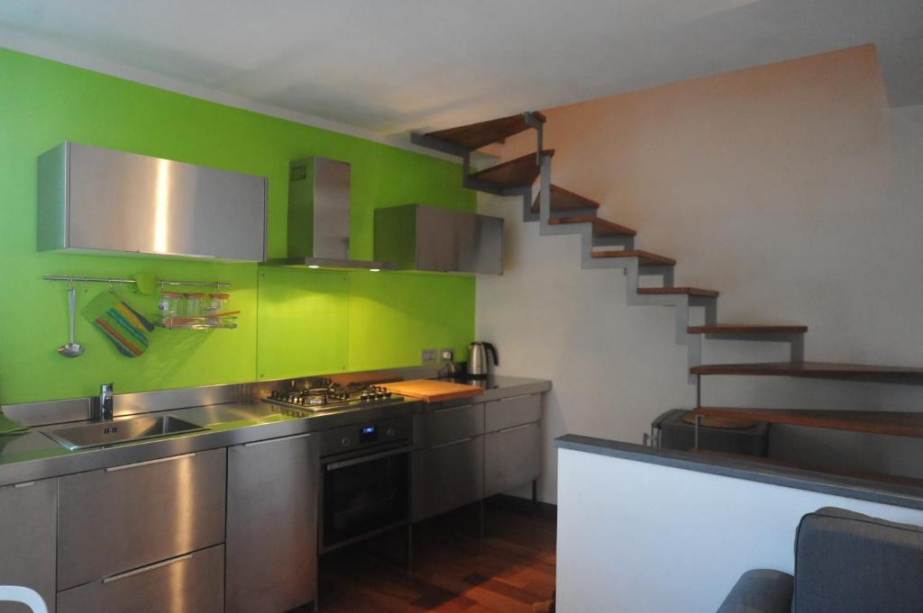 a kitchen with green walls and stainless steel appliances at Casa Vacanze La Fontana in Lerici