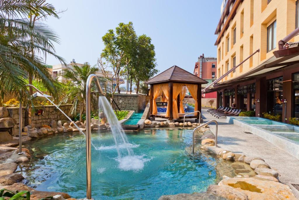 a water fountain in a pool with a gazebo at The Loft Seaside Suites in Jinshan