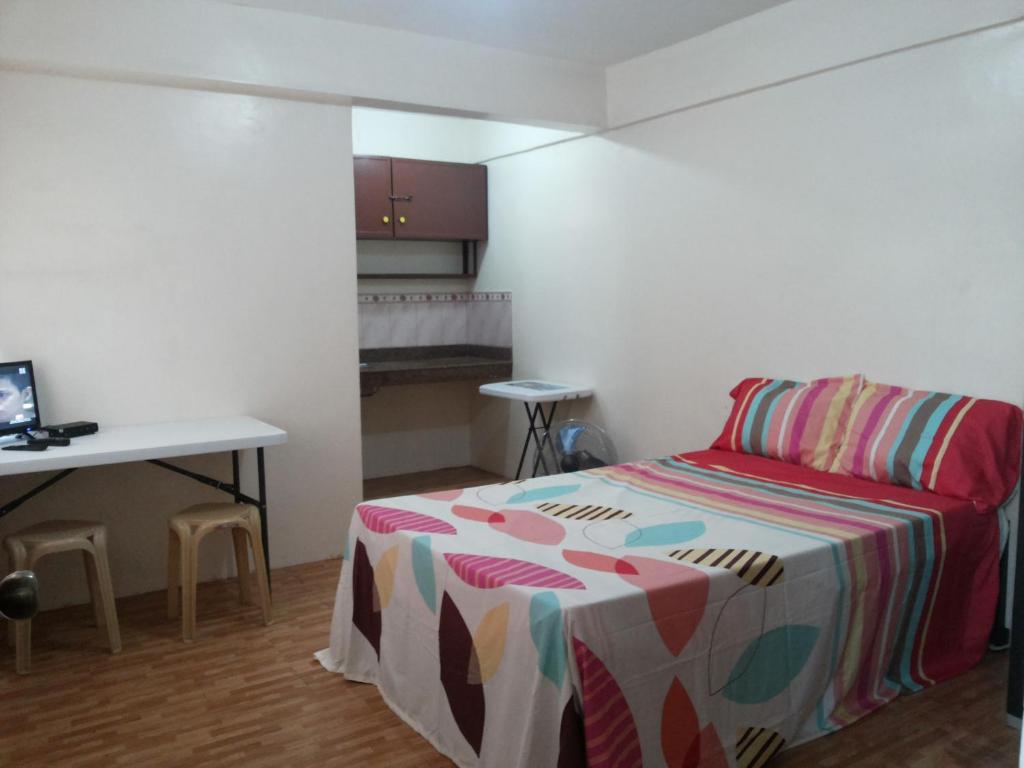 una camera da letto con un letto, un tavolo e una scrivania di Budget Studio Unit in Makati a Manila