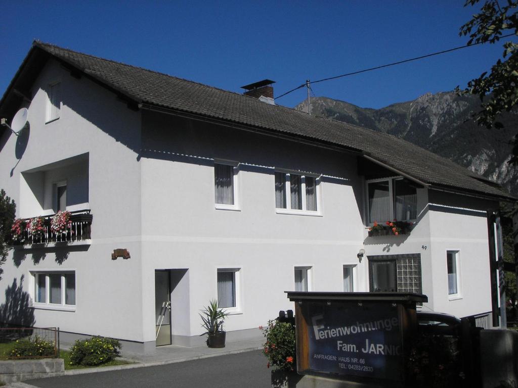 un edificio blanco con un cartel delante en Ferienwohnungen Familie Jarnig Inge en Görtschach