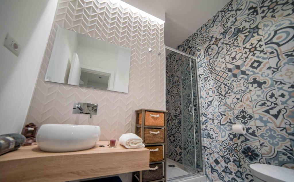 łazienka z umywalką i lustrem w obiekcie B&B Mareè Seafront Molfetta w mieście Molfetta